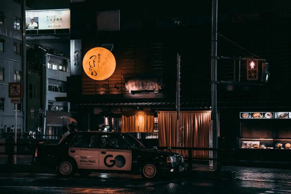 a taxi cab parked in front of a building at night