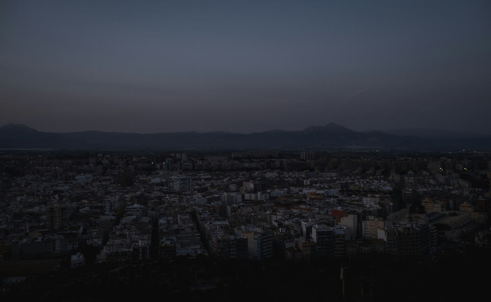 a view of a city at night with mountains in the background