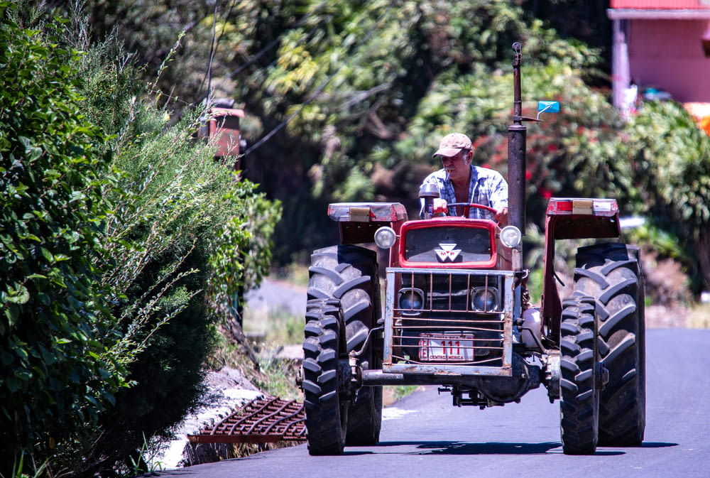 a man driving a tractor down a street