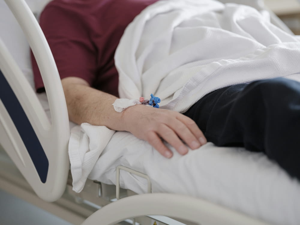 a man laying in a hospital bed with a cast on his arm