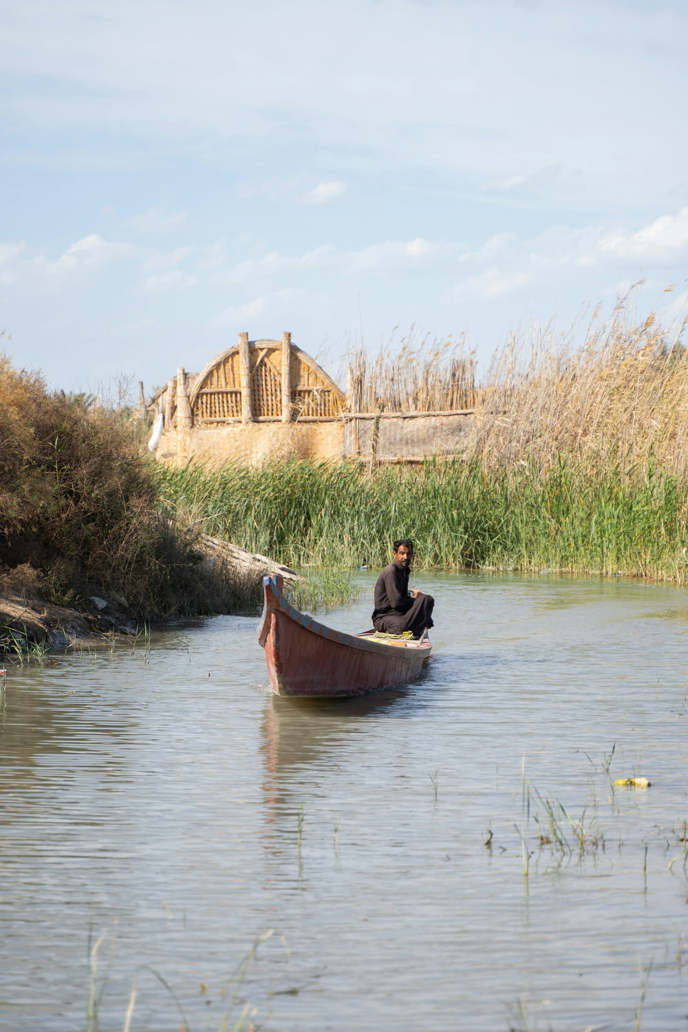 um homem sentado em um barco em um rio