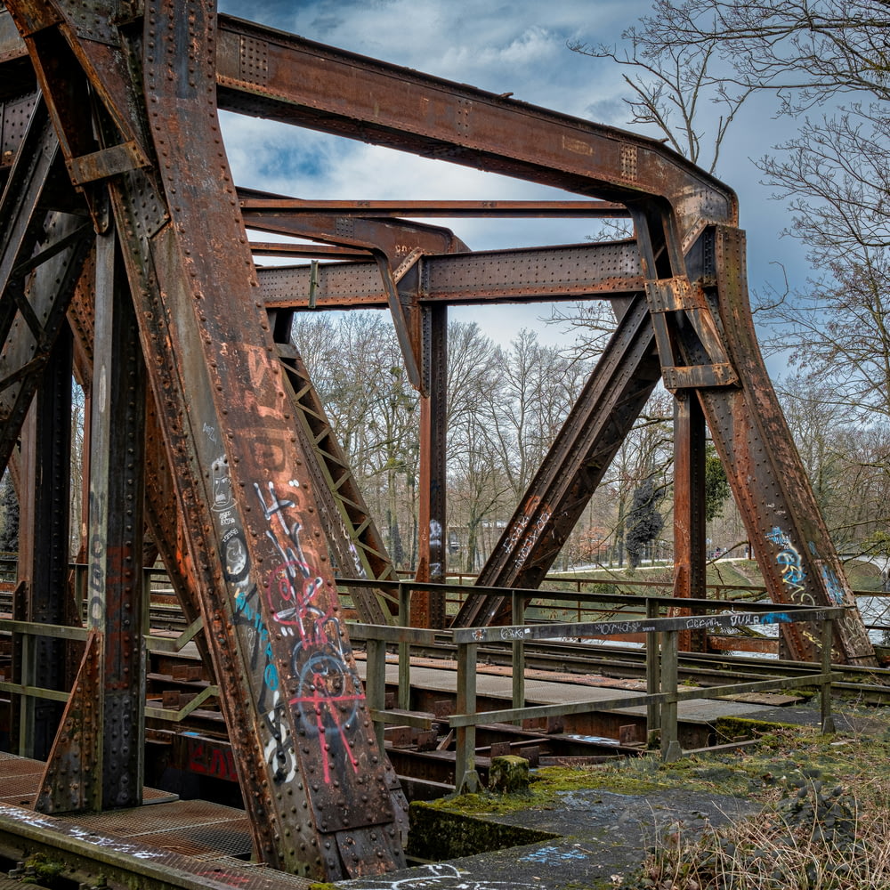 an old rusty bridge with graffiti on it