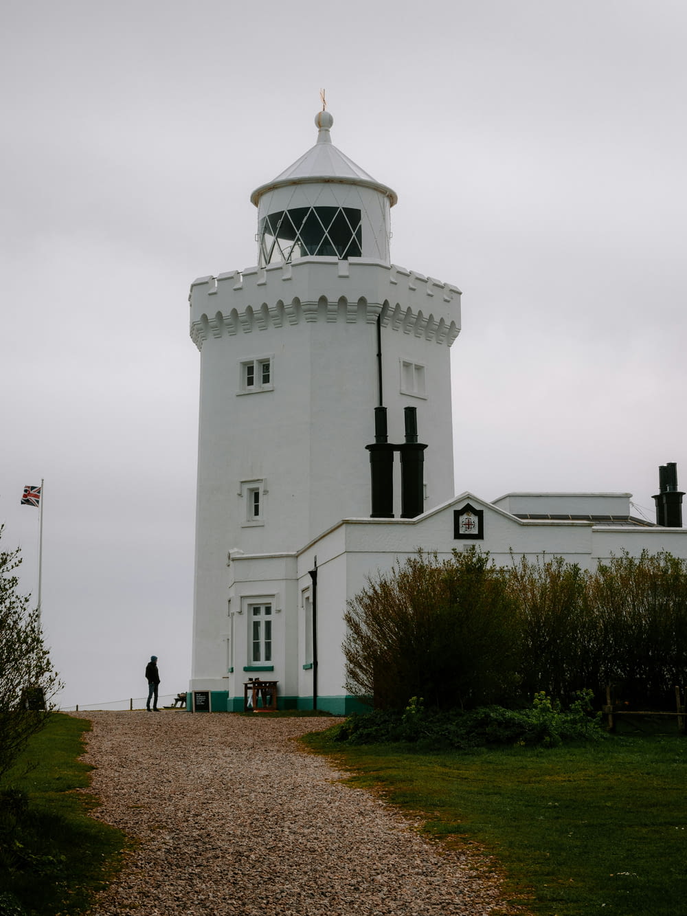 a person standing in front of a white lighthouse