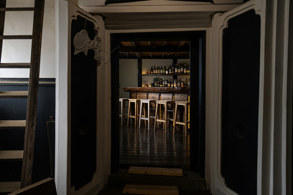 a narrow hallway leading to a bar with stools