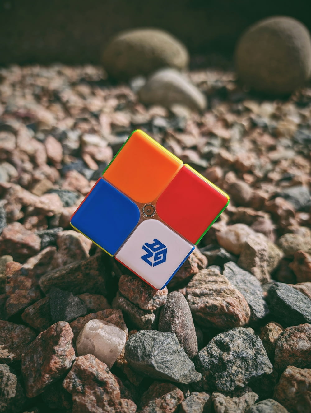 a rubik cube sitting on top of a pile of rocks