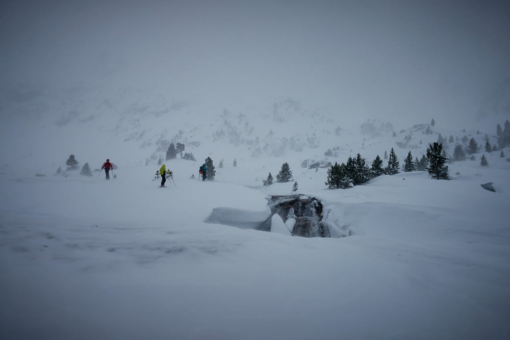 a group of people walking across a snow covered slope
