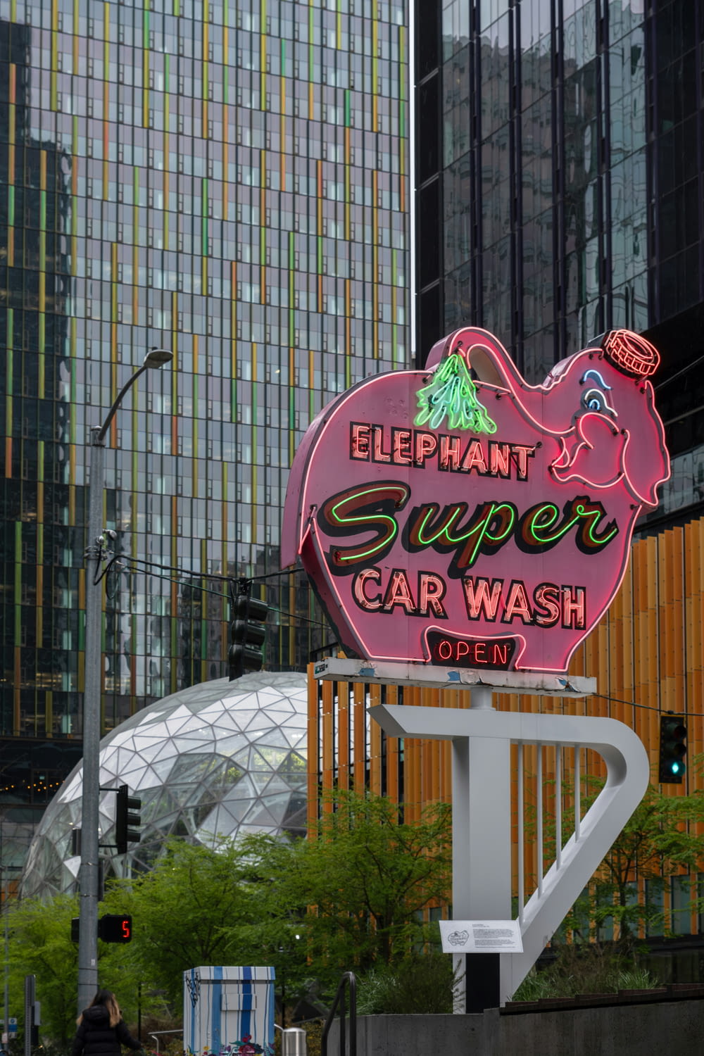 a neon sign for elephant super car wash in a city