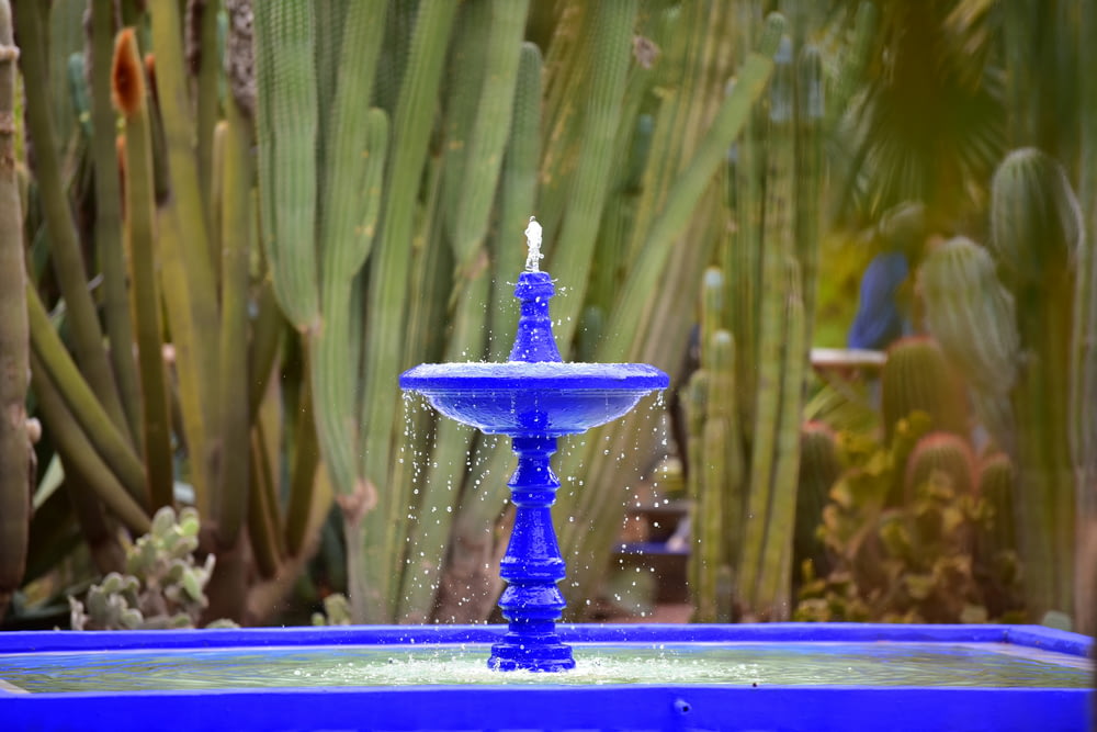 a blue fountain with a lit candle in it