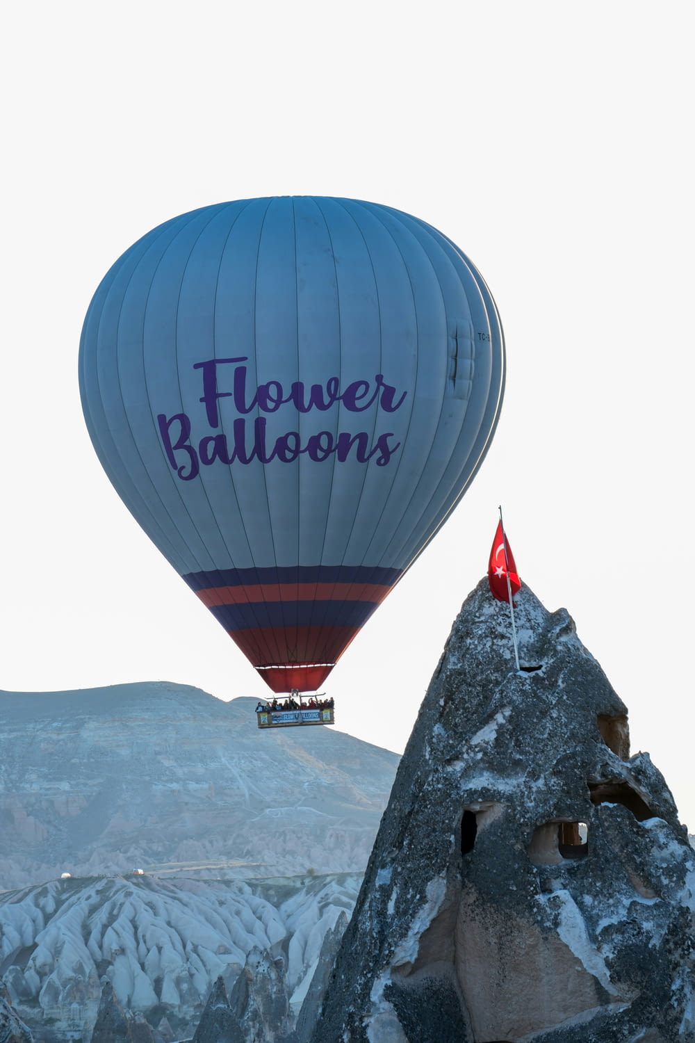 a hot air balloon flying over a mountain