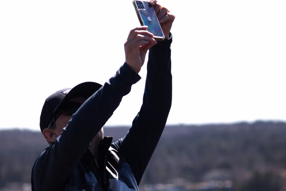 a man holding up a cell phone in the air
