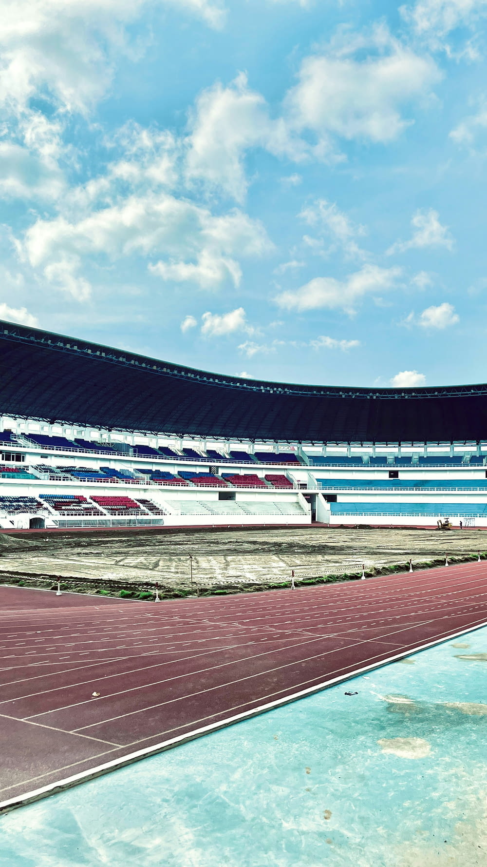 an empty stadium with a blue sky and white clouds