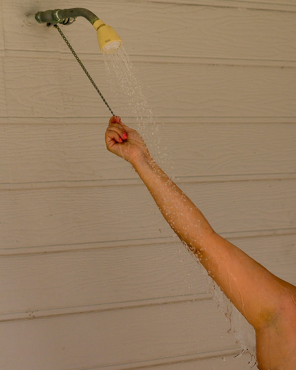 a person is spraying water from a shower head