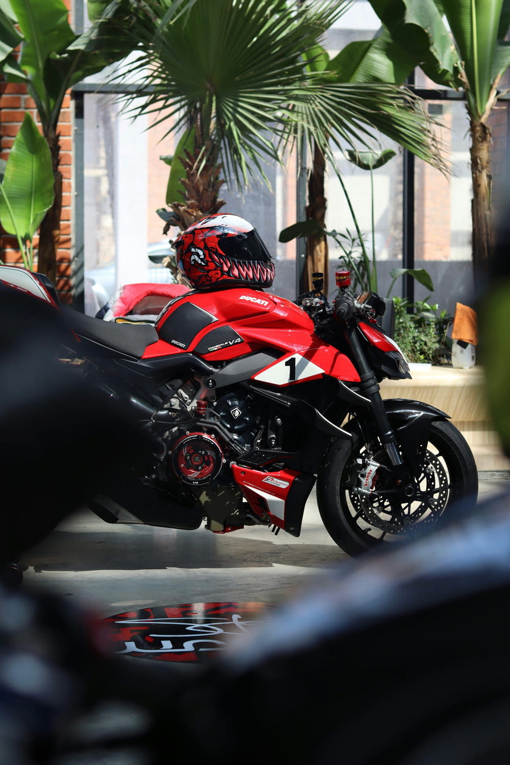 a red and black motorcycle parked in front of a building