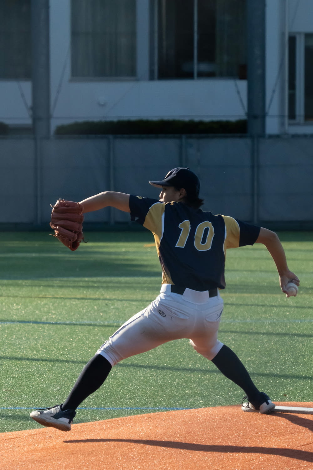 a baseball player pitching a ball on top of a field