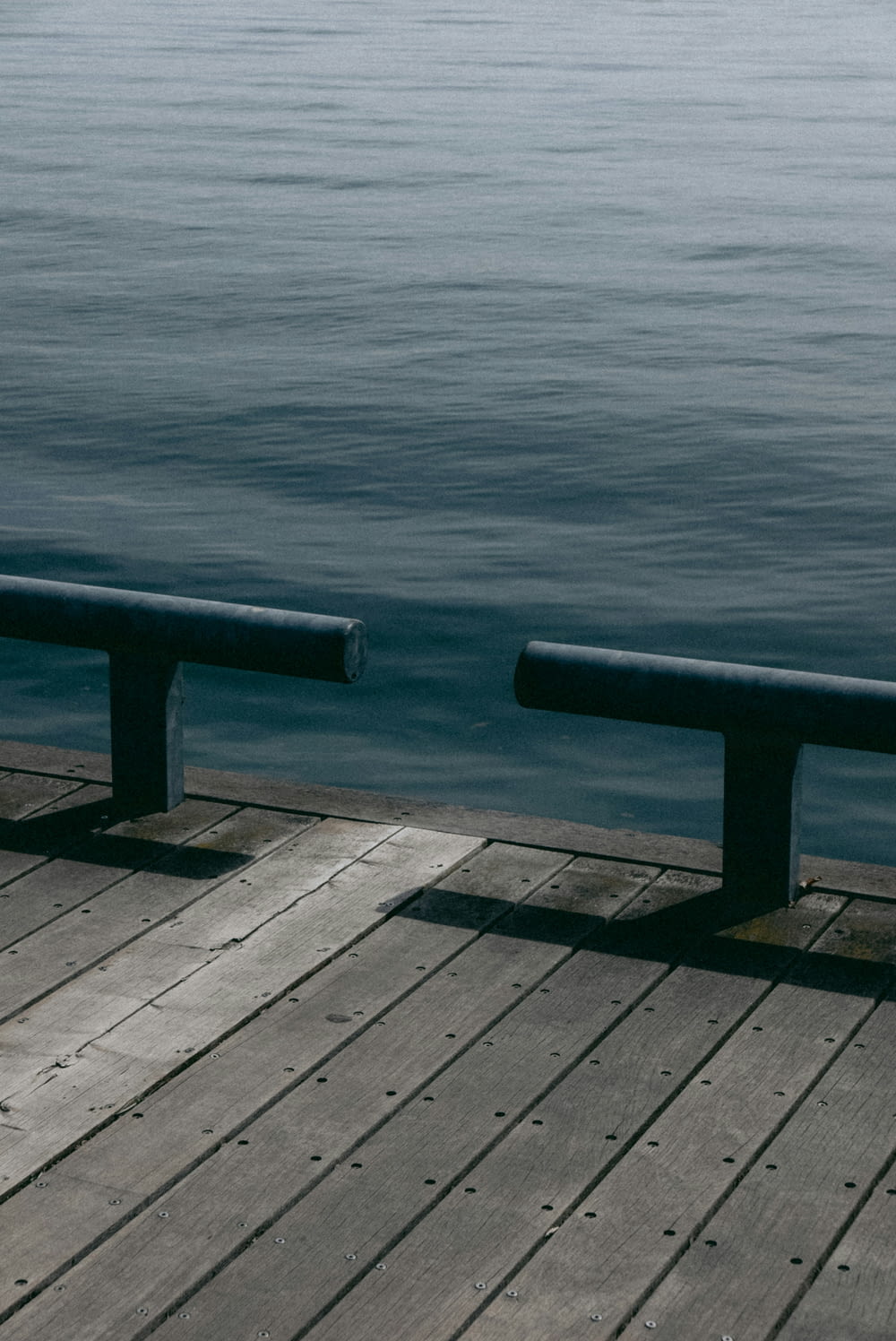 a couple of benches sitting on top of a wooden pier