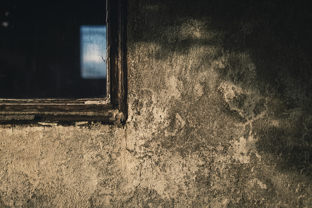 a window on a wall with a dark background