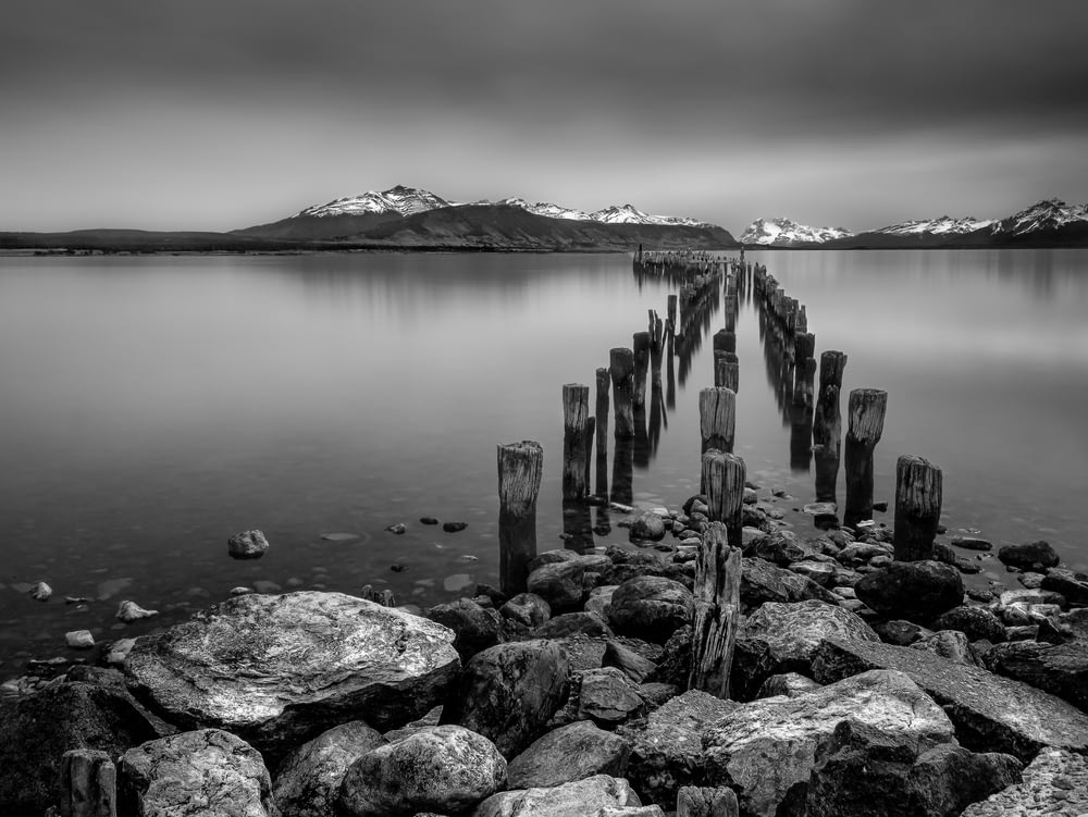 a black and white photo of a dock on a lake