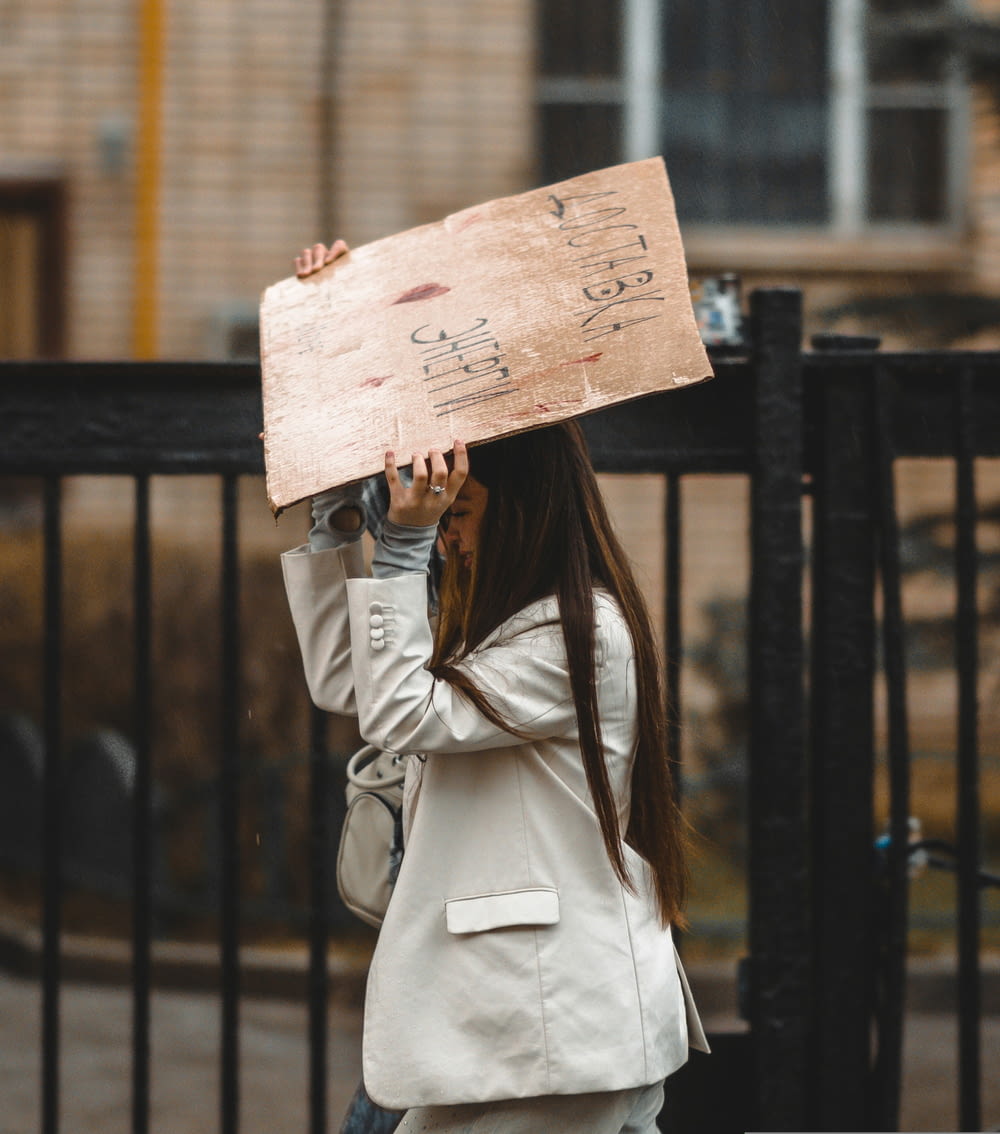 a woman holding a sign with writing on it
