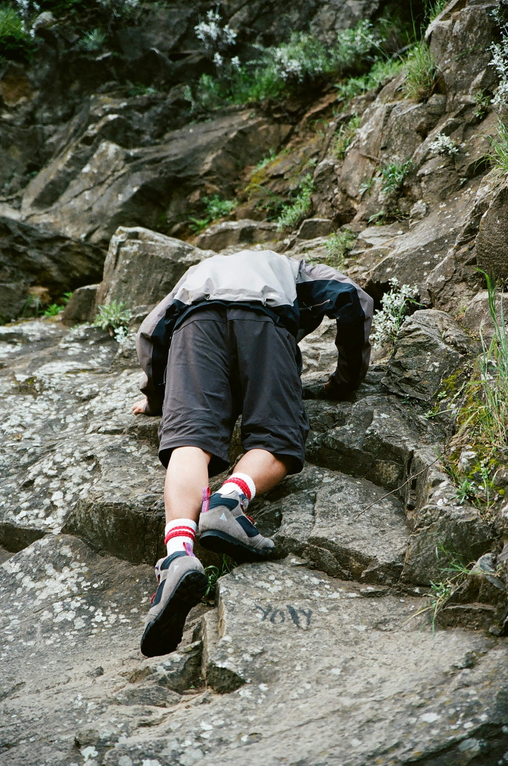 um homem deitado no topo de uma encosta rochosa