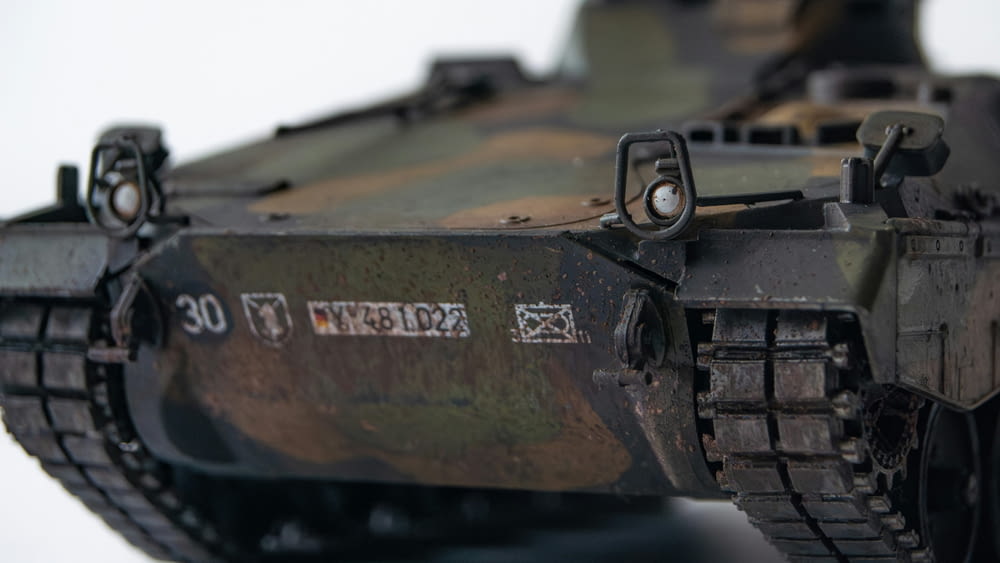 a close up of a toy tank on a white surface