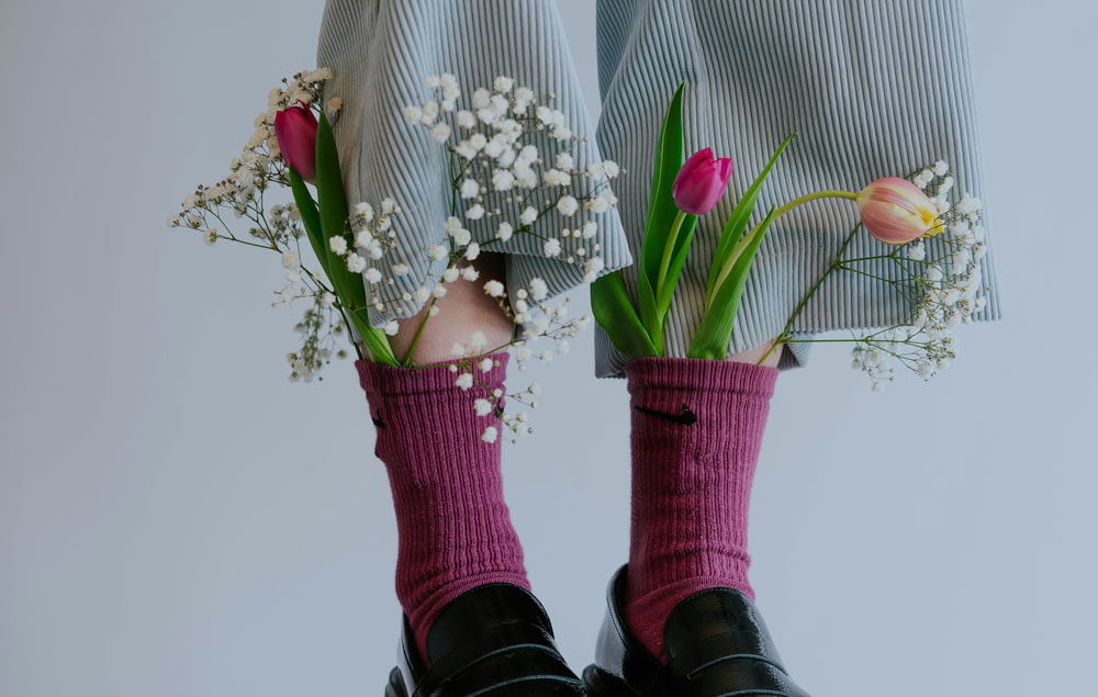 a pair of legs with flowers in their socks