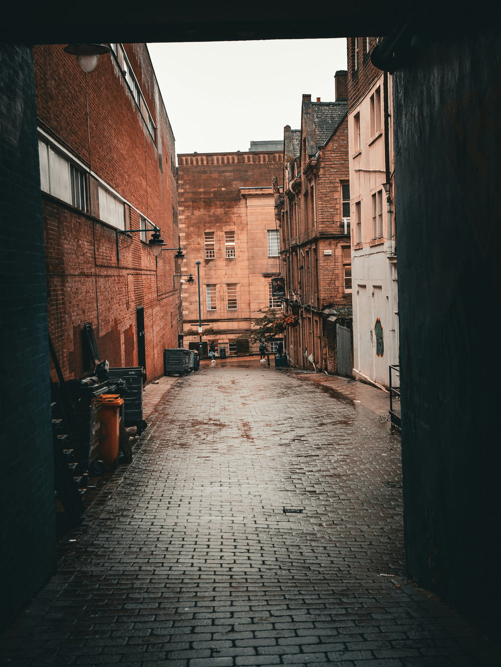 an alley way with a brick walkway between two buildings