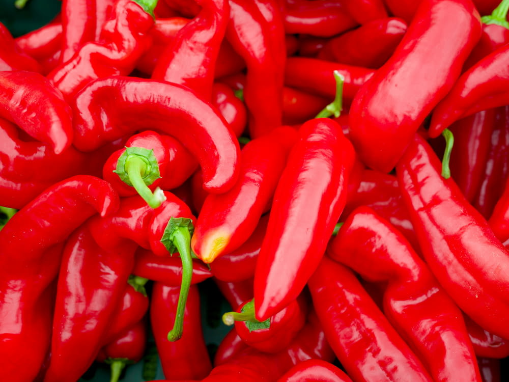 a pile of red hot peppers sitting next to each other