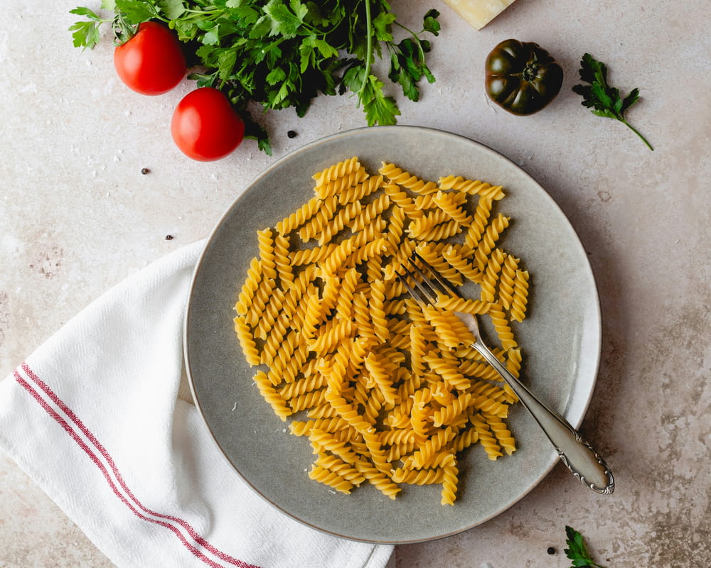 a plate of pasta with parsley and tomatoes