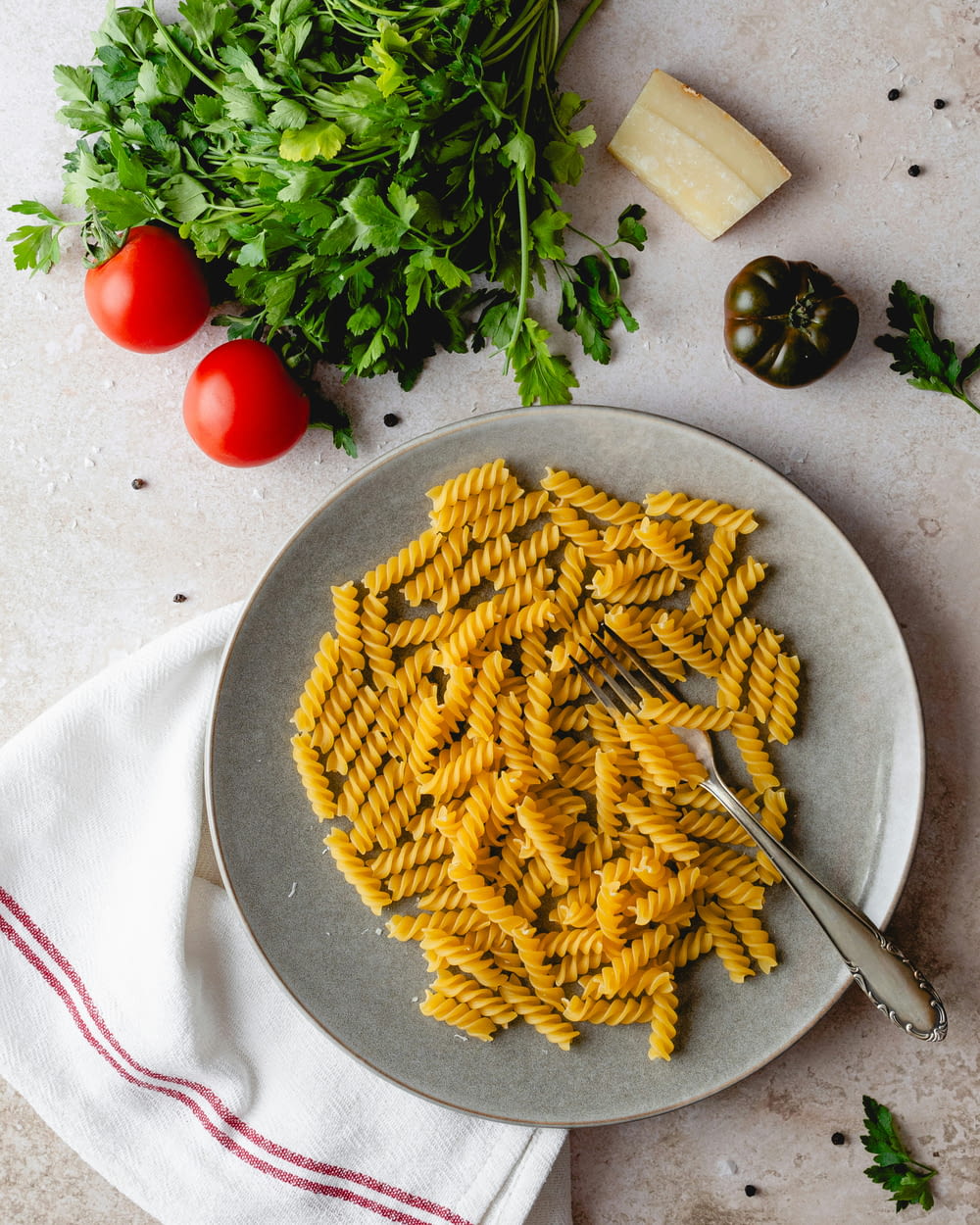 a plate of pasta with parsley and tomatoes