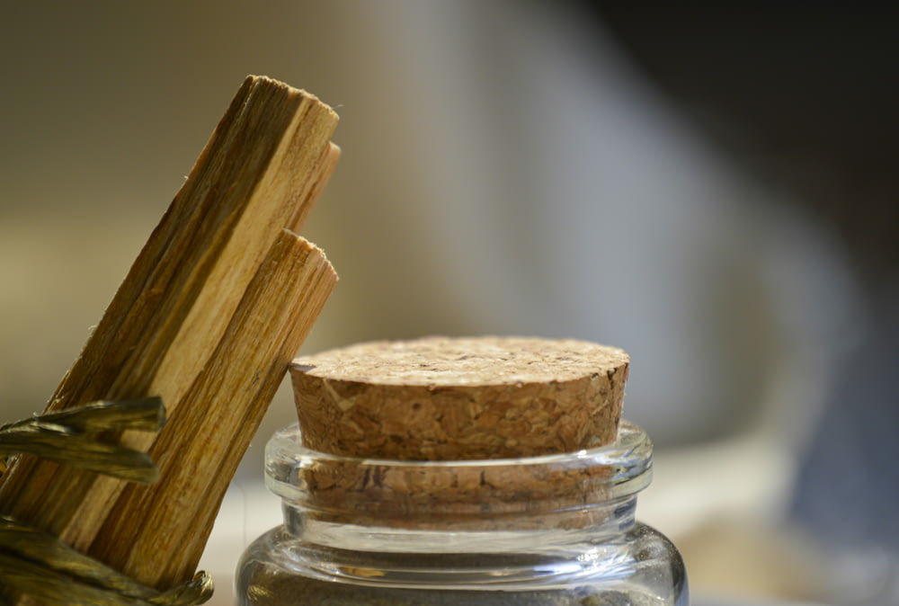 a close up of a glass jar with a wooden stick in it