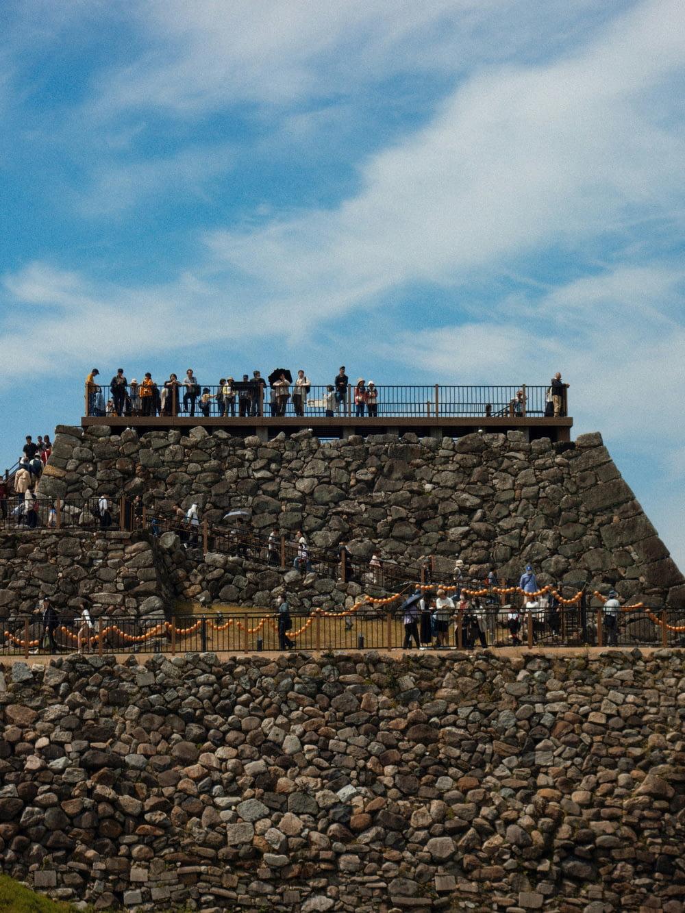 un gruppo di persone in piedi in cima a un muro di pietra