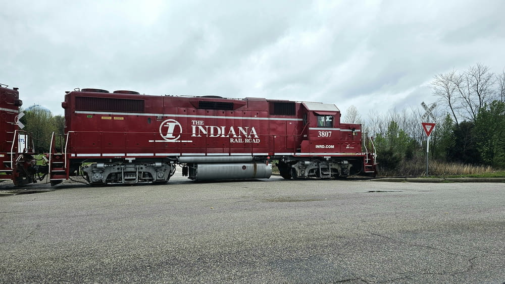 a red train car sitting in a parking lot