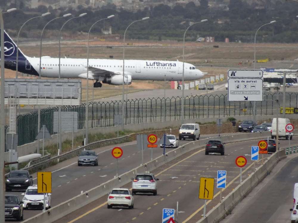 a large passenger jet flying over a busy highway