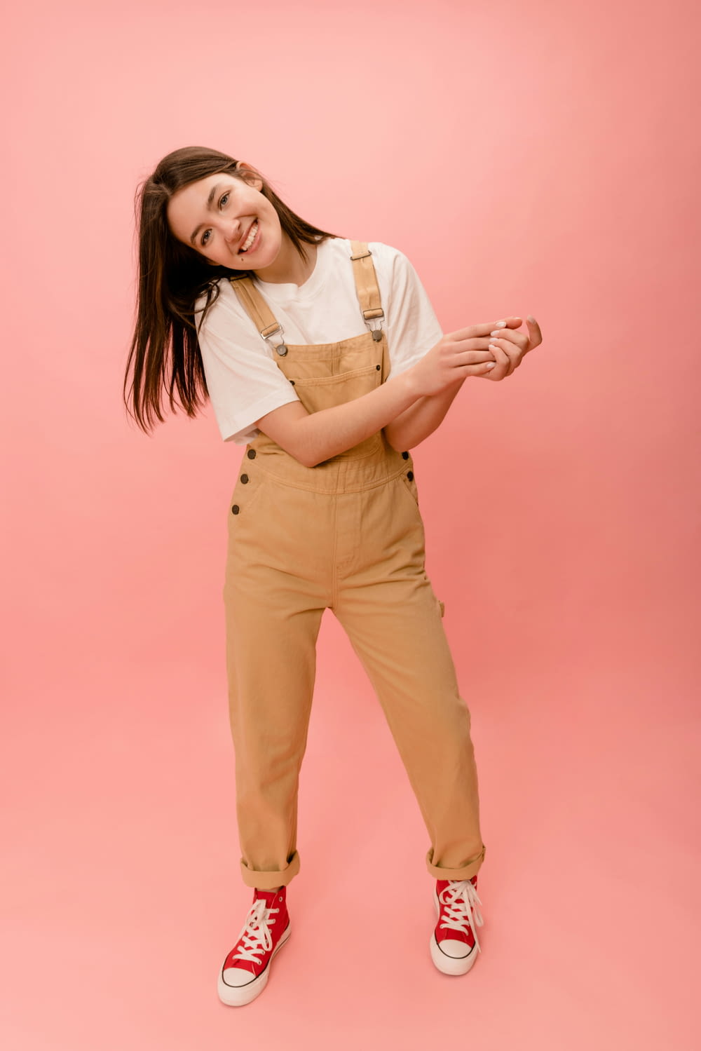 a woman in overalls posing for a picture