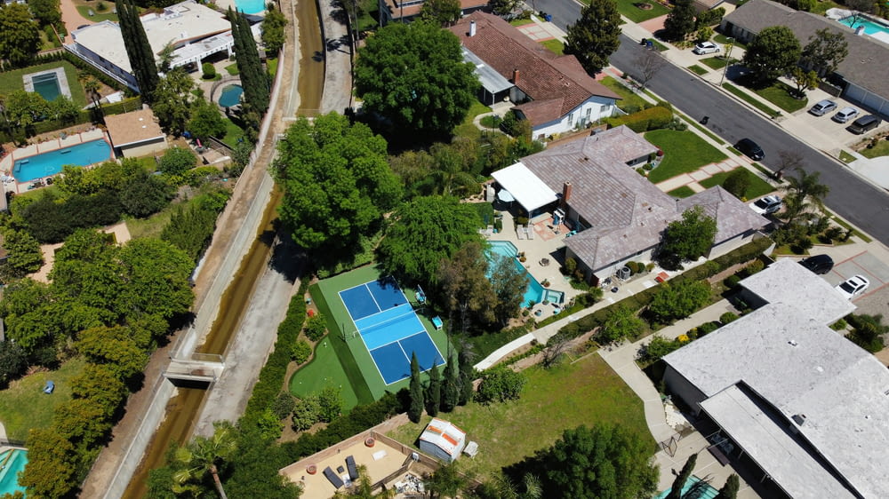 an aerial view of a neighborhood with a tennis court