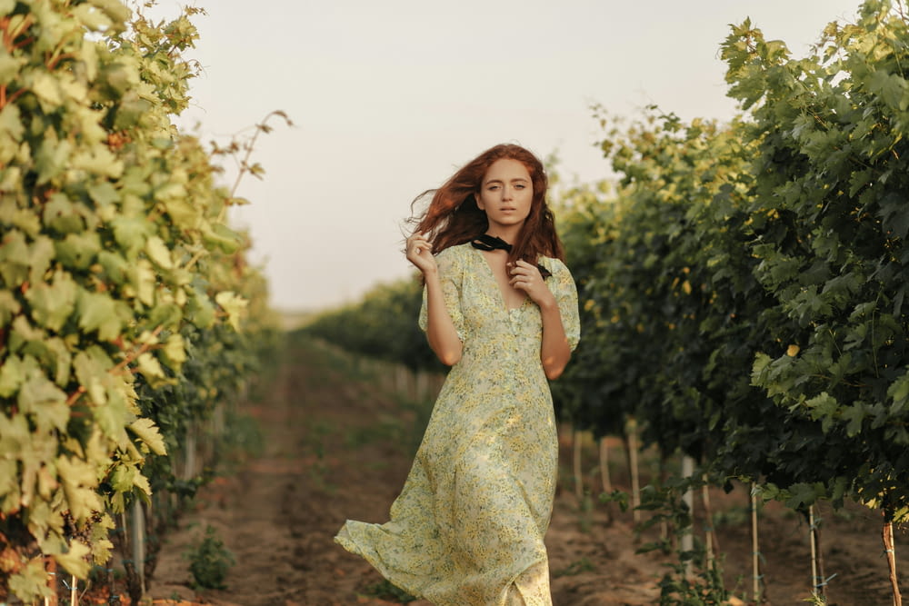 a woman standing in a field of vines