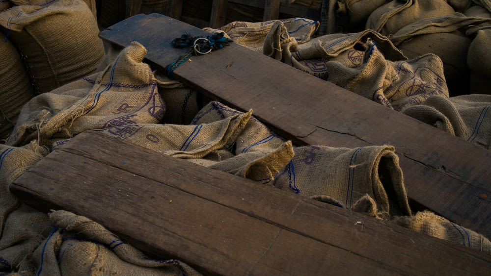 a pile of bags with a wooden board on top of it