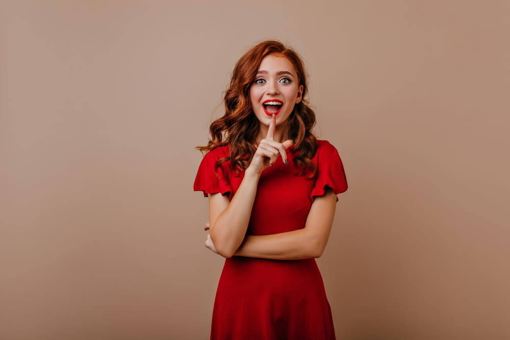 a woman in a red dress making a funny face