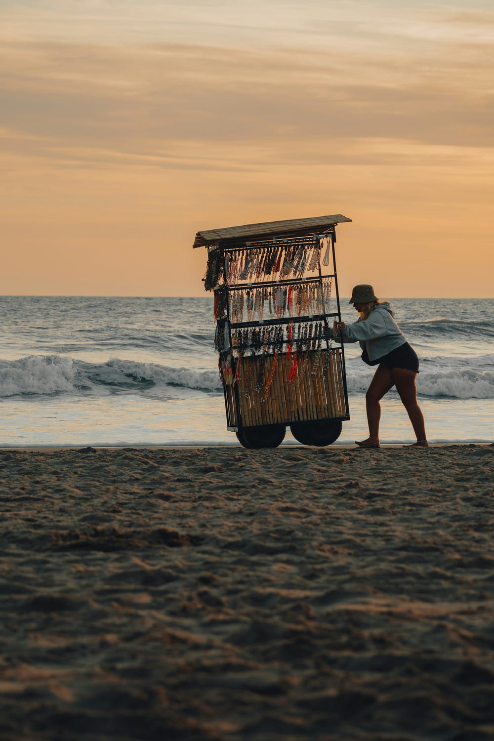 a woman pushing a cart on the beach