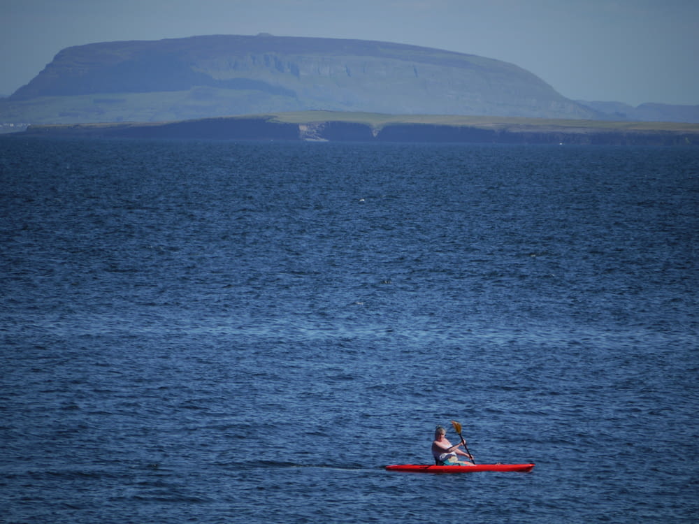 a person in a red kayak on a large body of water
