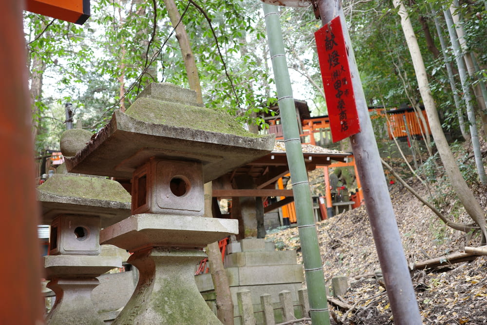 a group of stone lanterns in a forest