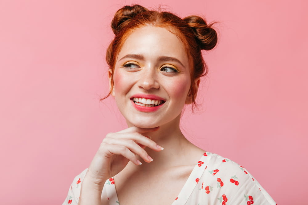 a woman with red hair is smiling and posing for a picture