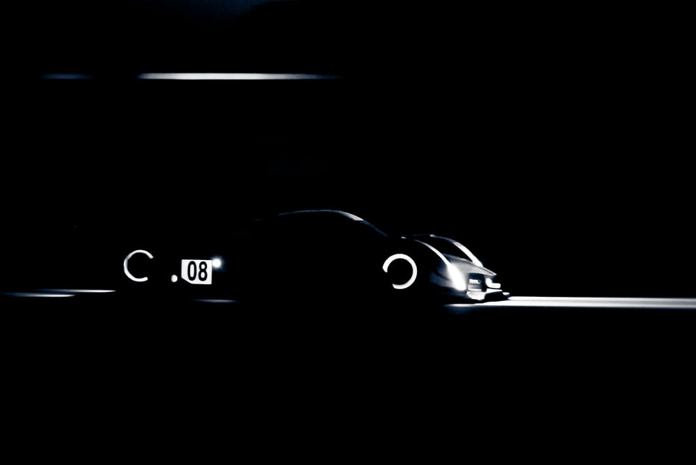 a car is shown in the dark with its lights on
