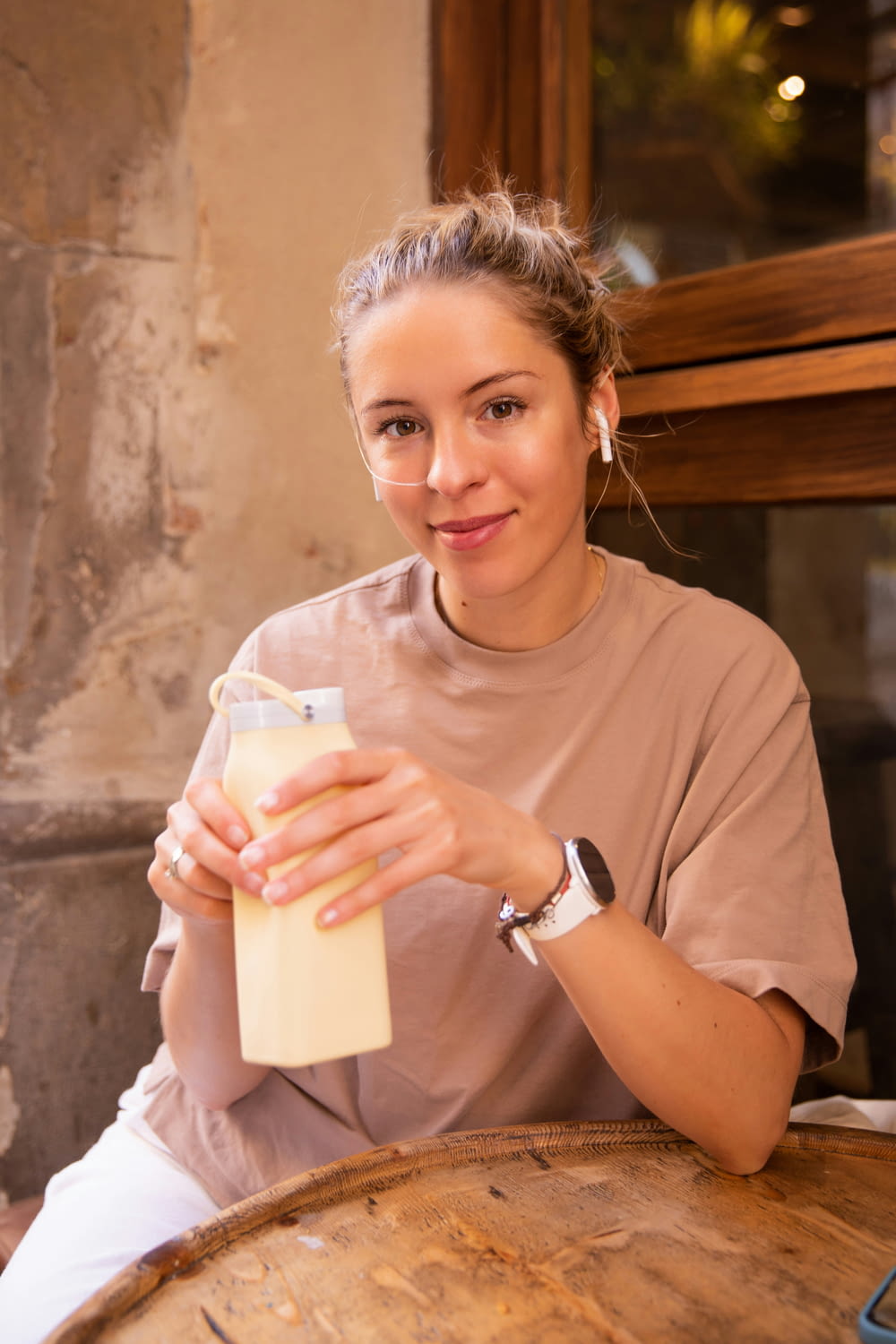 a woman sitting at a table holding a bottle of milk