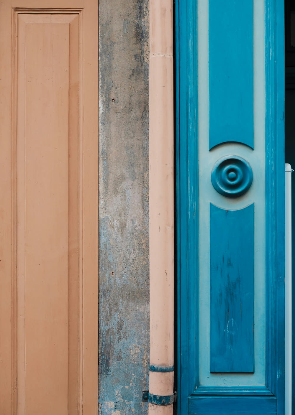 uma porta azul e uma porta marrom com uma maçaneta azul