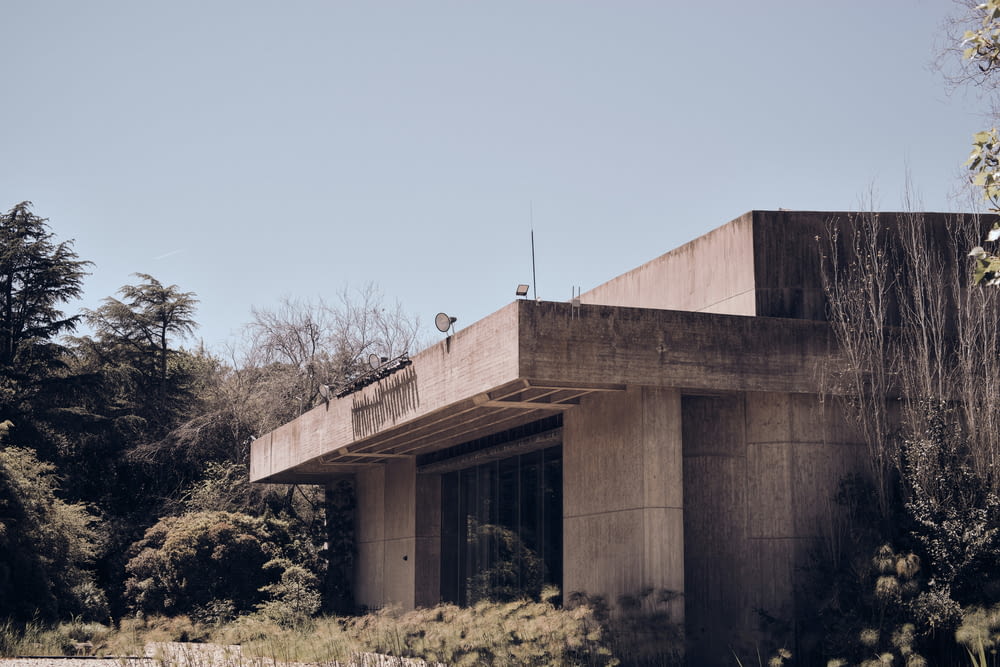 a concrete building with trees in the background