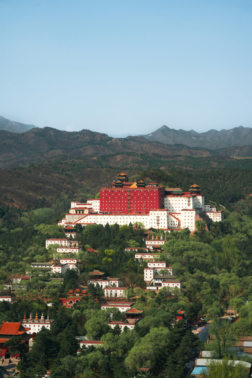 a large red building on top of a lush green hillside