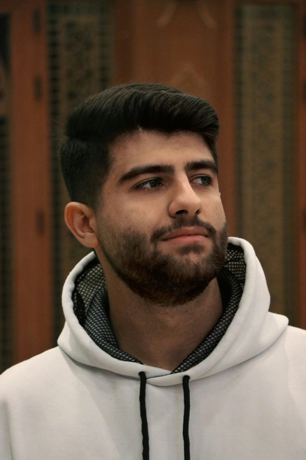 a man with a beard wearing a white hoodie