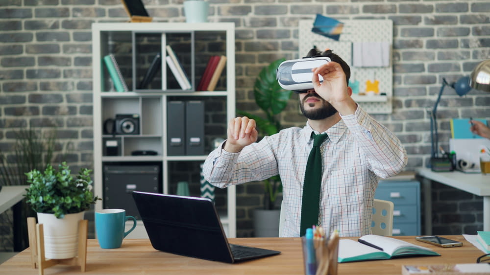 a man in a tie is using a laptop while wearing a virtual headset