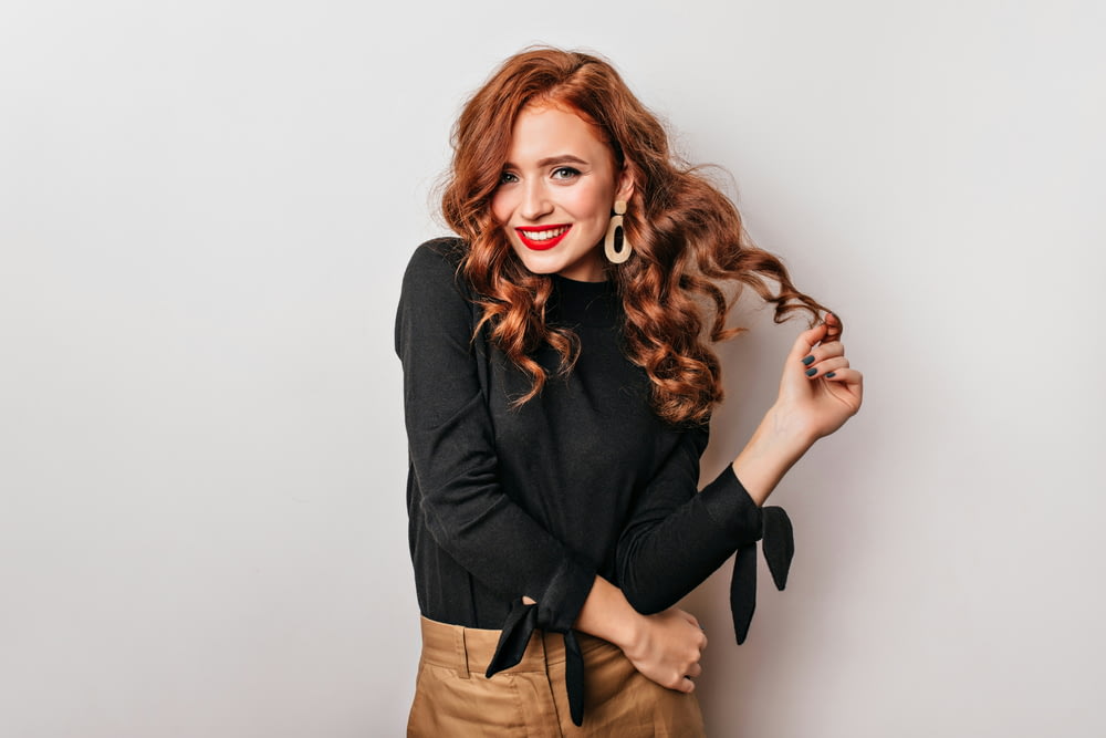 a woman with long red hair wearing a black shirt